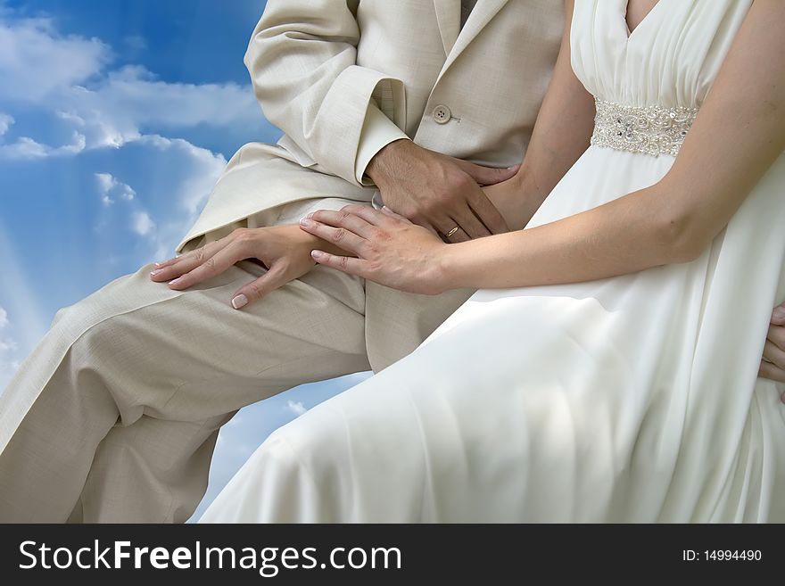 Man   woman  groom  the young husband and the wife on wedding with hands together a metaphor in the cloudy shining sky