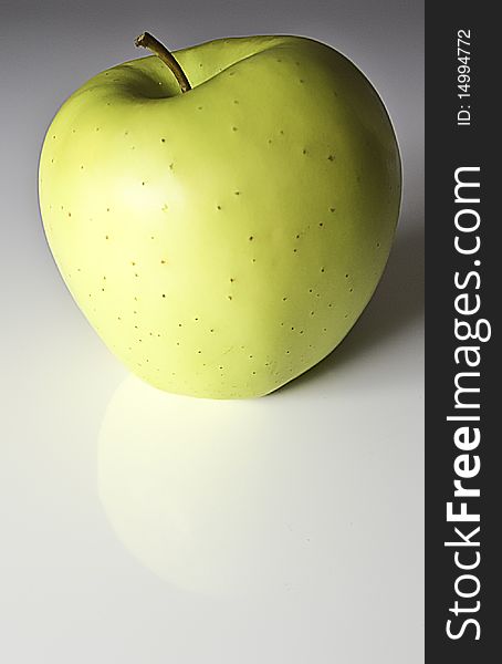 Smooth-skinned yellow apple on white background