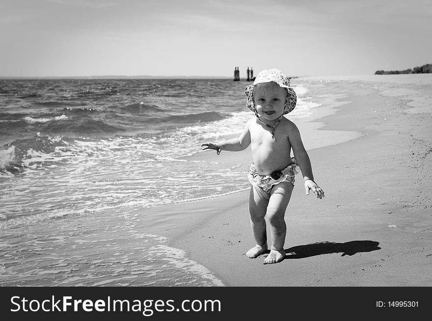 Image of the happy baby on the beach . black and white.