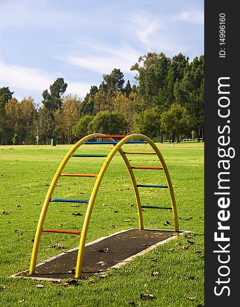 A colourful childrens playground equipment with tree background