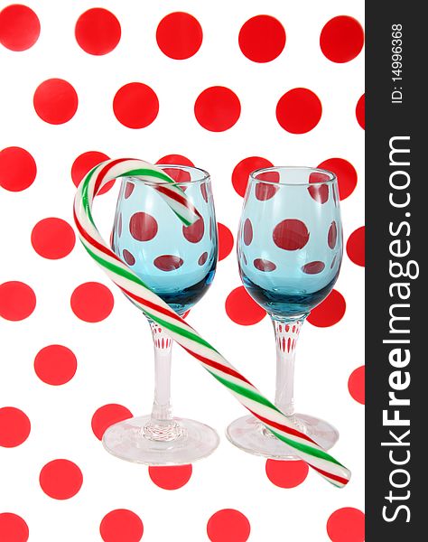 Two blue stained glasses with a candy cane on a polkadot background