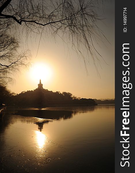 Beihai Stupa with Sunset and Mountains in Background, taken from Jinshang Park, Beijing, China Trademarks removed.