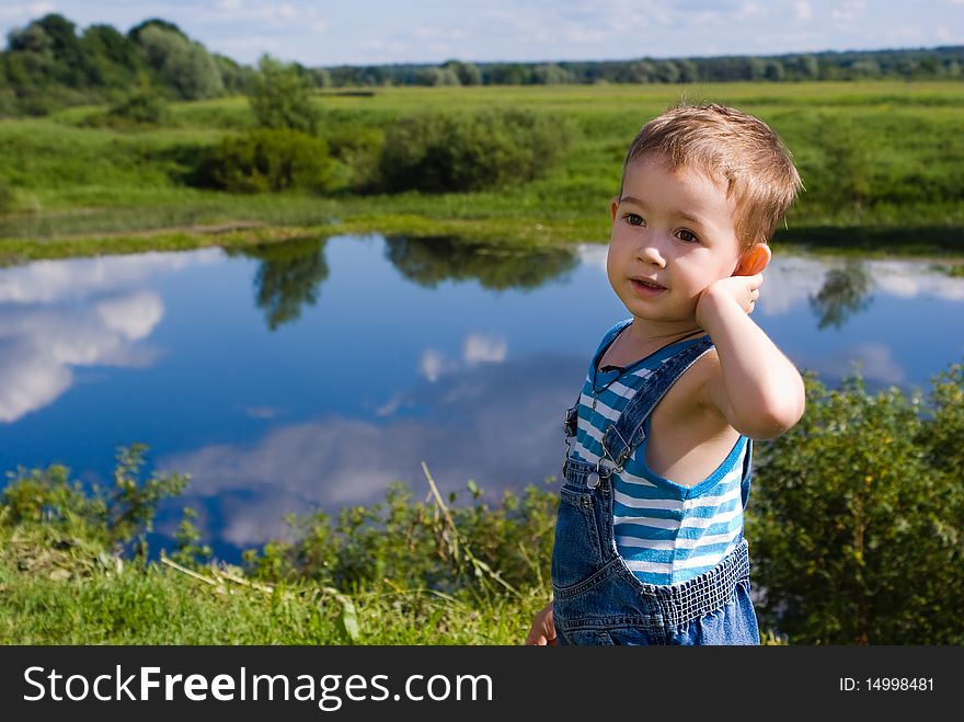 Little boy on a summer lake background. Little boy on a summer lake background