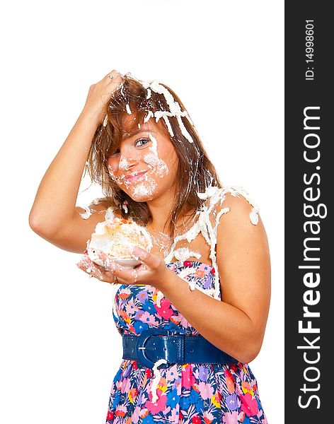 Girl eating cake with his hands, her face and head stained cream.