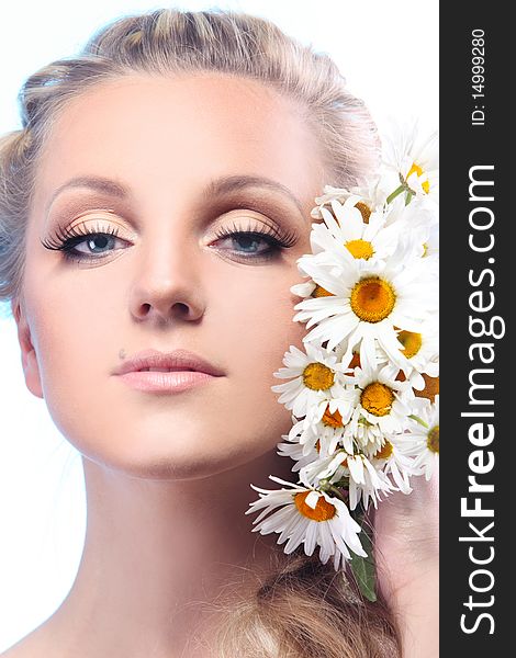 Close-up portrait of a fresh and beautiful woman with camomile.