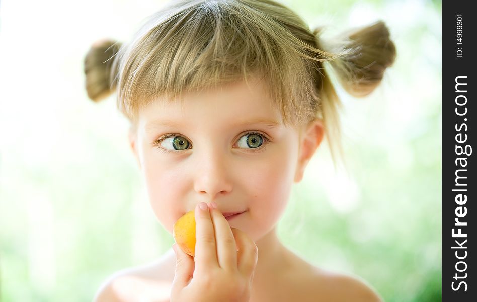 Close-up portrait of a cute liitle girl with the apricot. Close-up portrait of a cute liitle girl with the apricot