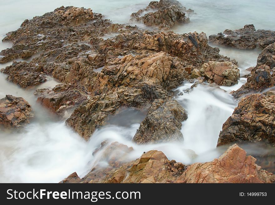 Rocks and ocean water flowing over them taken with slow shutter speed. Rocks and ocean water flowing over them taken with slow shutter speed