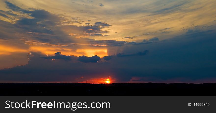 Sunset. The sun shining through low cloud