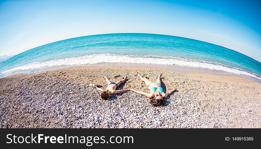 The boy with his mother sunbathe on the beach