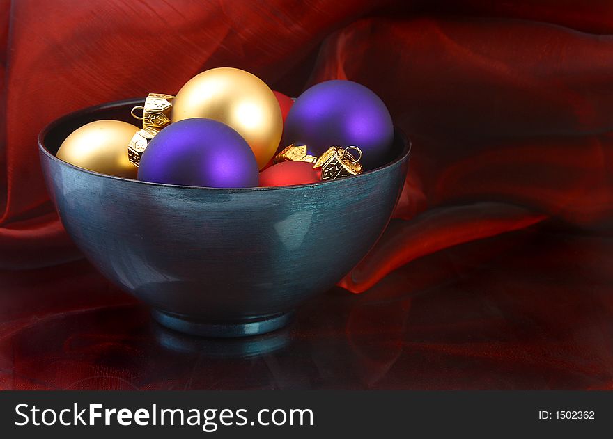 A turqoise bowl of multi colored ornaments. A turqoise bowl of multi colored ornaments