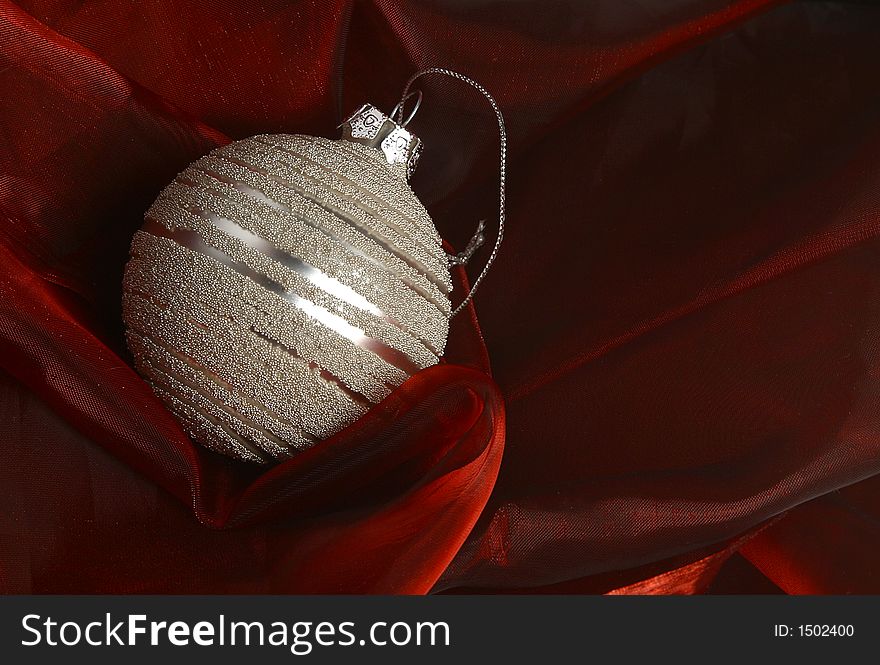 A silver ornaments on red fabric