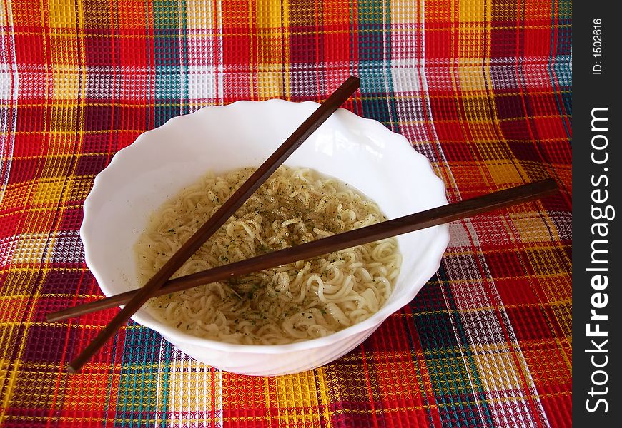 The welded noodles in a bowl with the Chinese sticks