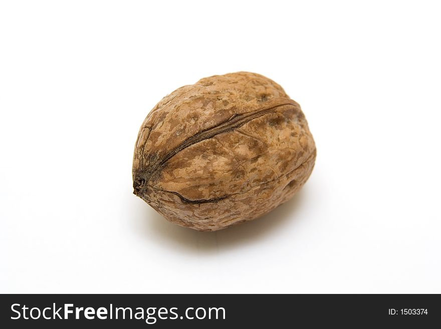 An isolated walnut in its shell close-up. An isolated walnut in its shell close-up