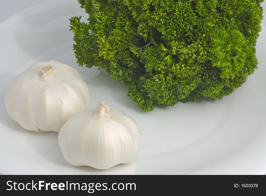 Garlic bulbs and green parsley. Garlic bulbs and green parsley