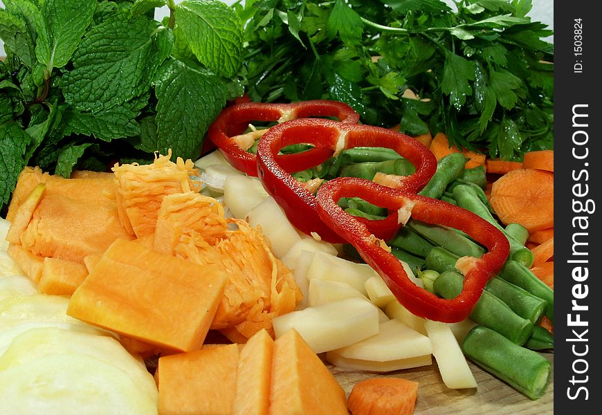 Fresh vegetables sliced on wooden table whit herbs