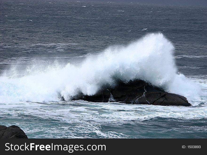 A large wave hit a rock at the sea. A large wave hit a rock at the sea