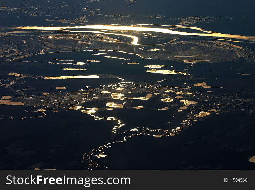 Bright reflections in rivers and waters, seen from a flying airplane in the night. Bright reflections in rivers and waters, seen from a flying airplane in the night