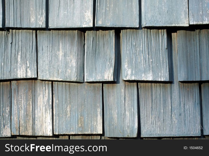 This is a close up image of the weathered wooden shingles on a house.