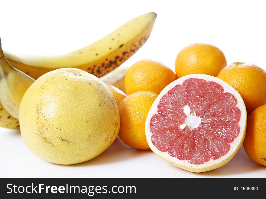 Assorted fruit over white - Includes grapefruit, clementines, bananas