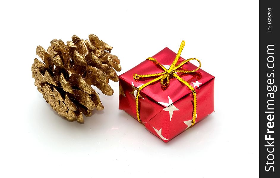 Symbols of christmas, a wrapped gift and a golden pine cone. Symbols of christmas, a wrapped gift and a golden pine cone
