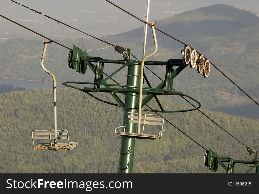 Ski lift and chairs with mountains  in the background