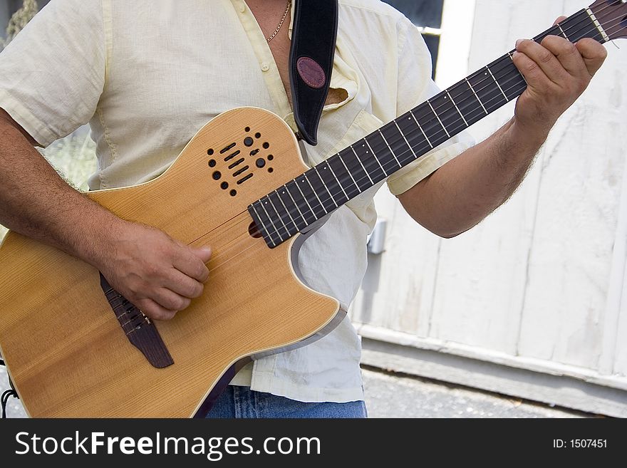 A Hispanic musician plays an electronic acoustic guitar. A Hispanic musician plays an electronic acoustic guitar.