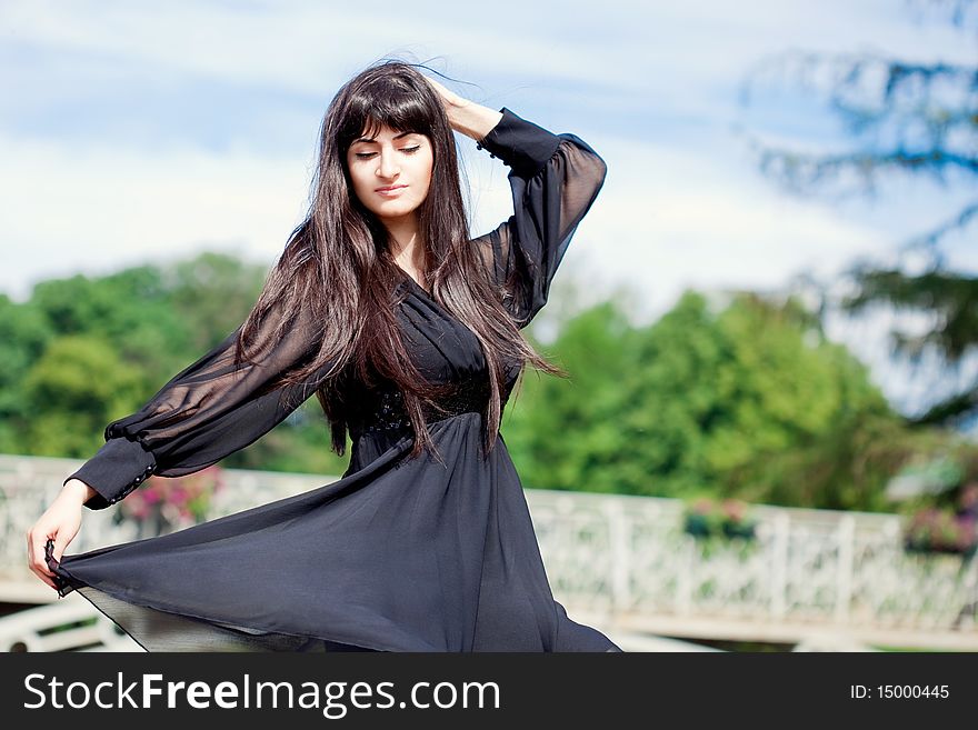 Young beautiful girl with long black hair, outdoors