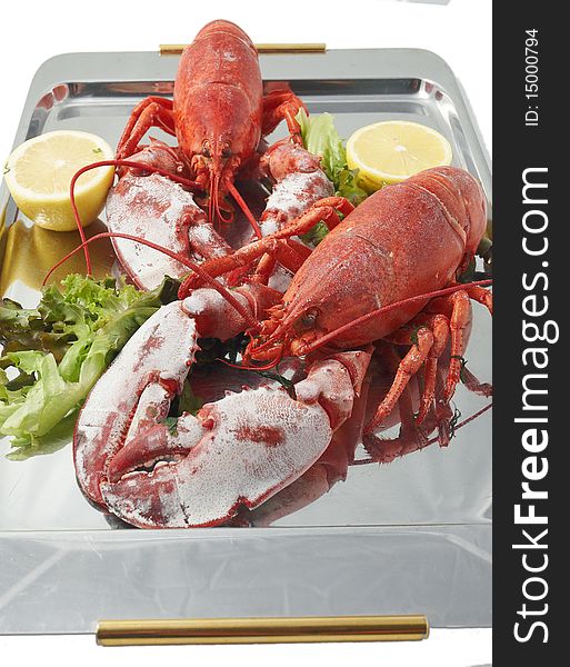 Steamed red boiled lobster with salad leaves and lemon in  restaurant . Steamed red boiled lobster with salad leaves and lemon in  restaurant .