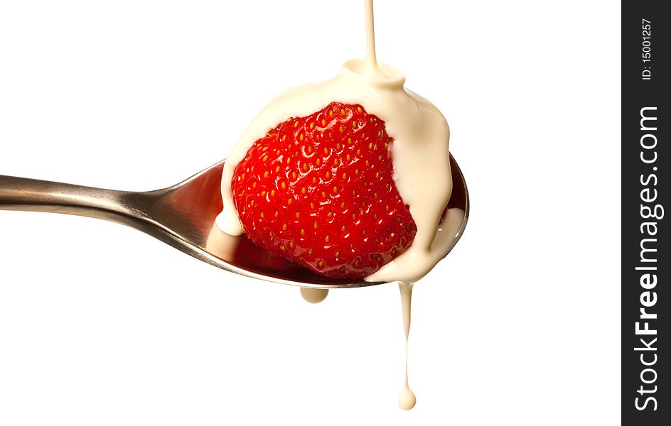 Fresh cream dripping on a strawberry sat in a spoon. Fresh cream dripping on a strawberry sat in a spoon