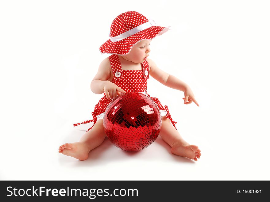 Little baby girl in red dress and hat with red ball
