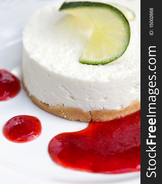 Fresh cheesecake served with lemon and strawberry sauce