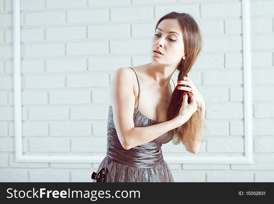 Romantic young lady combing in beautiful dress