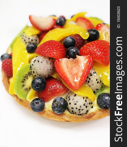 Closeup of a mixed fruits tart on white background