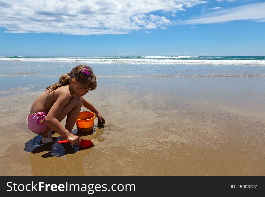 A girl playing on the wet sand