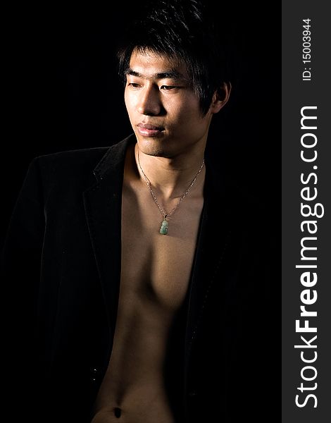 A handsome man on black background,exposing his fit breast. A handsome man on black background,exposing his fit breast