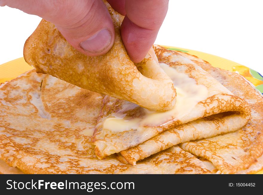 The hand takes fried pancakes with a butter. The hand takes fried pancakes with a butter