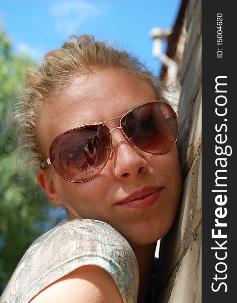 Young beautiful woman in brown sunglasses, closeup. Young beautiful woman in brown sunglasses, closeup