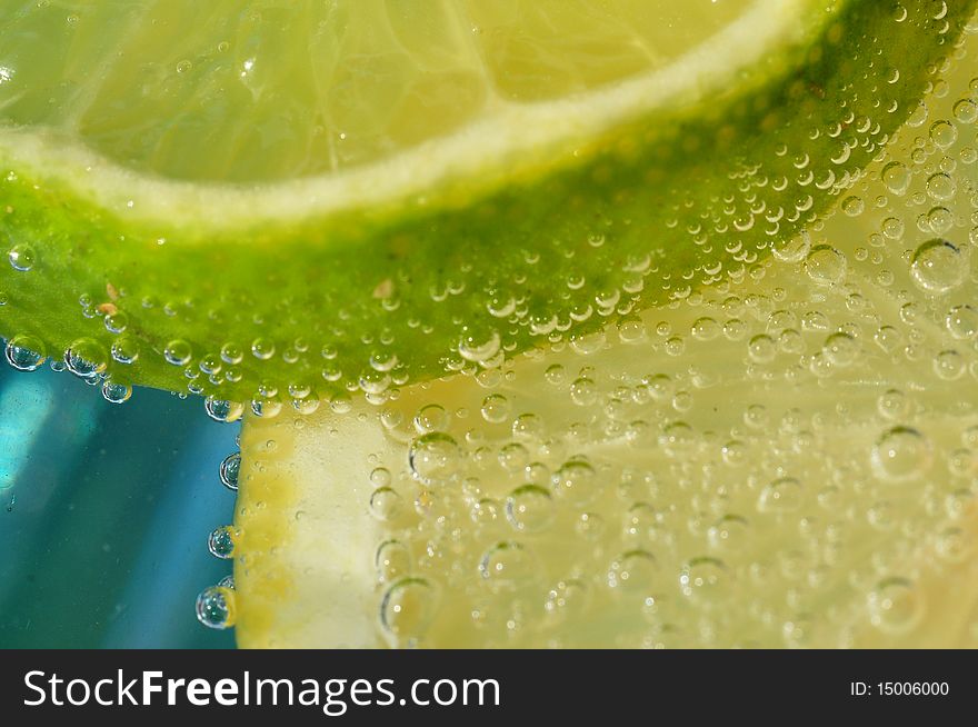 Close up/macro image of a lemon and lime slice in carbonated water. Close up/macro image of a lemon and lime slice in carbonated water.