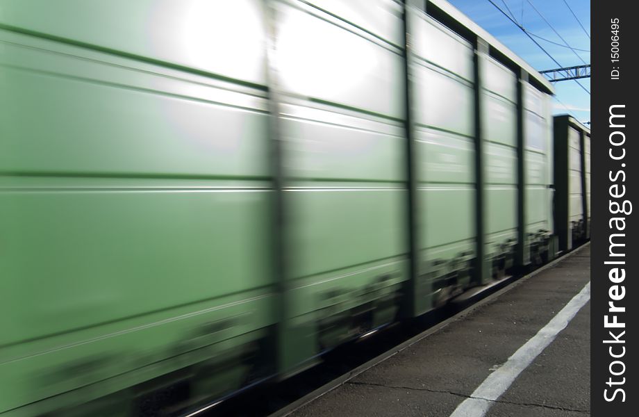 Green boxcar in motion photo from platform