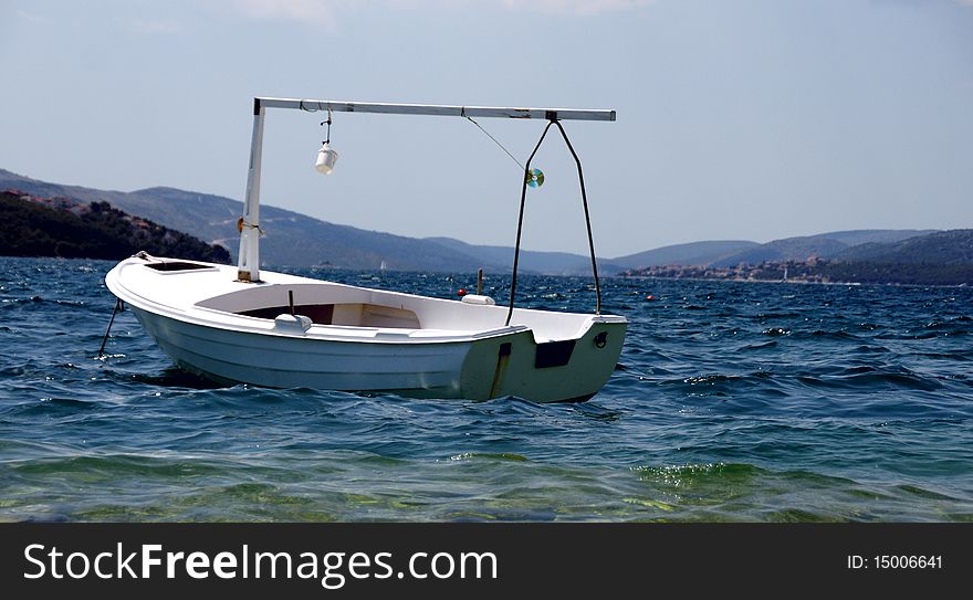 The spirit of holidays - small white boat on the sea waves