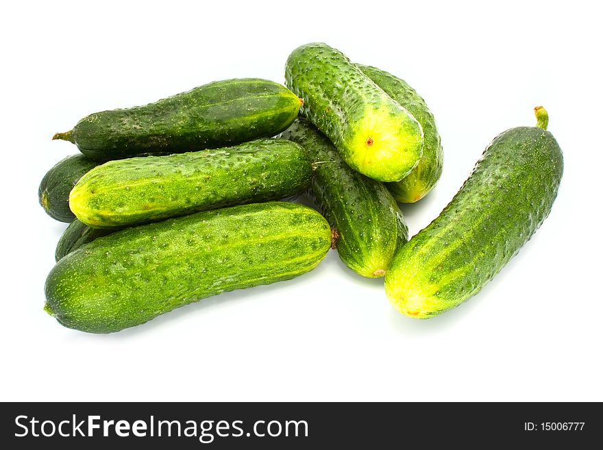 Fresh cucumbers broken from a bed lying on a white background