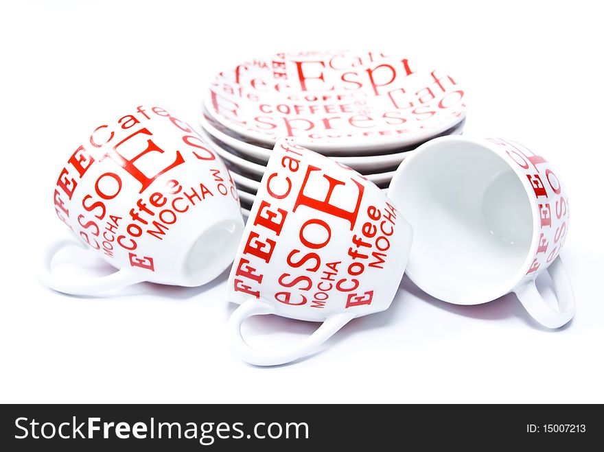 Three ceramic coffee cups lying around the stack saucers round shape, on a white background
