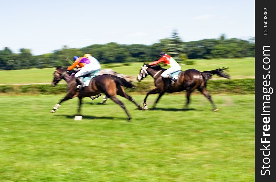 Horse racing on green racecourse, motion blurred. Horse racing on green racecourse, motion blurred