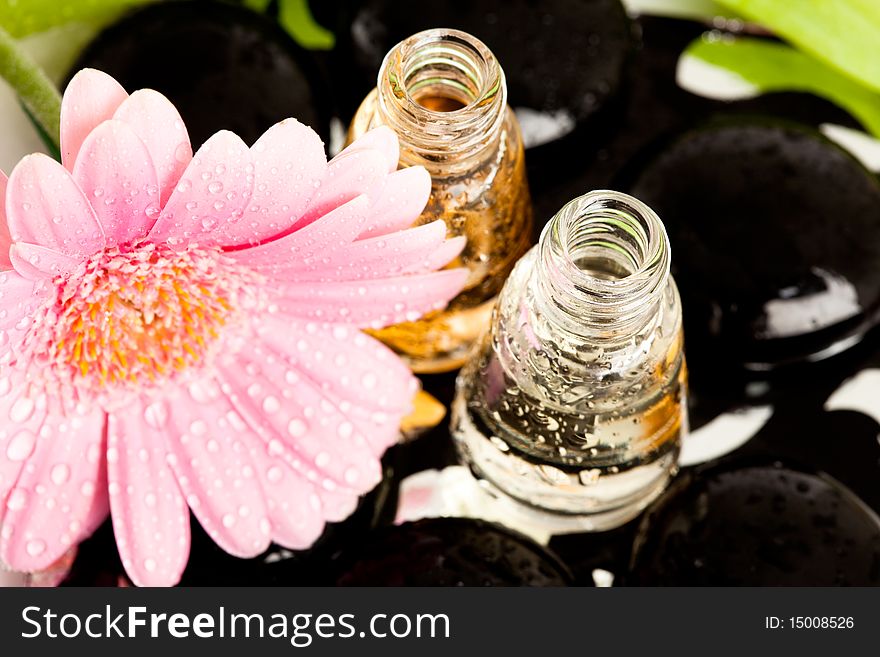 Spa essentials (stones with flower and bottles of oil)