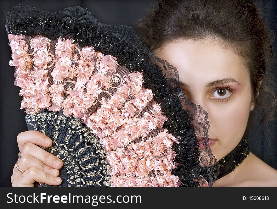 Portrait of a beautiful young girl with a fan