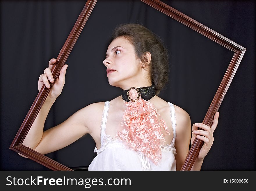 Beautiful young girl with a wooden frame in the hands of. Beautiful young girl with a wooden frame in the hands of