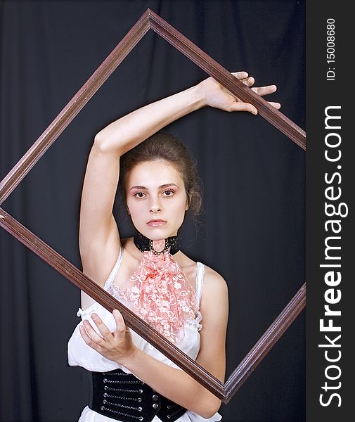 Beautiful young girl with a wooden frame in the hands of. Beautiful young girl with a wooden frame in the hands of