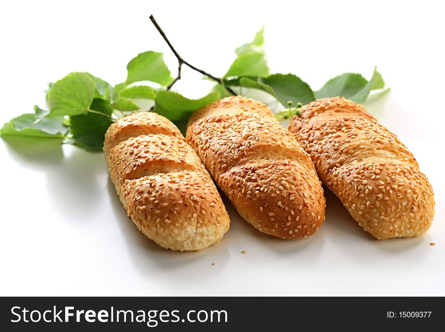 Three bread rolls with birch leaves on background