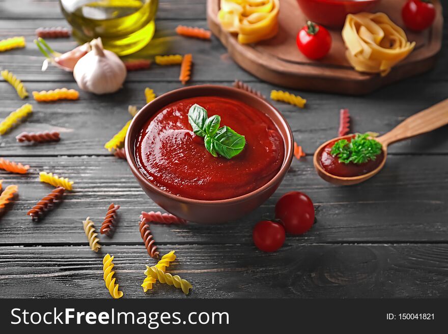 Bowl With Tasty Tomato Sauce On Wooden Table