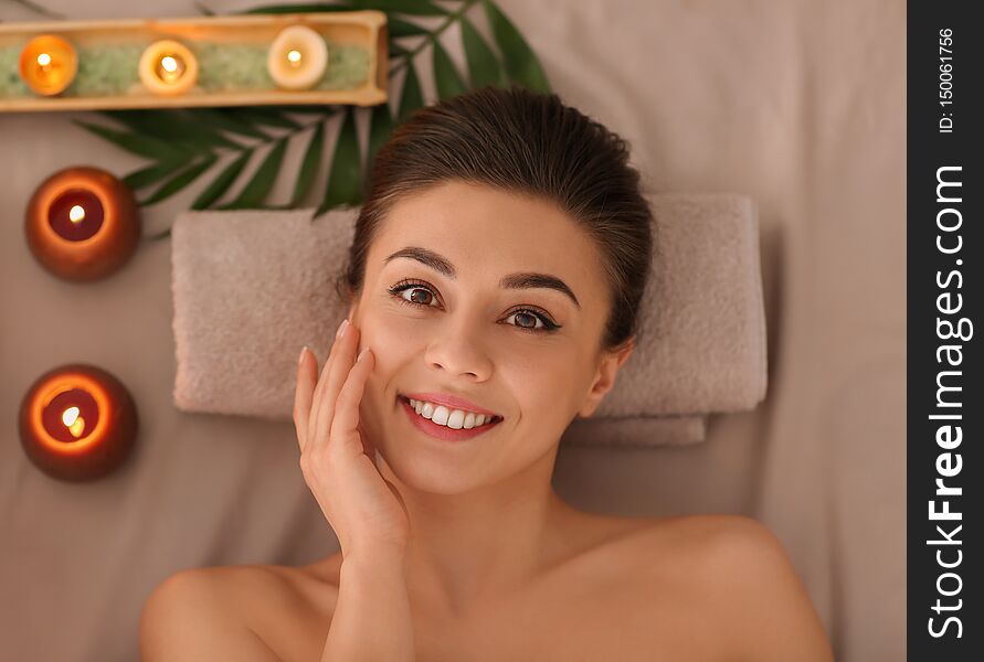 Happy young woman relaxing in spa salon